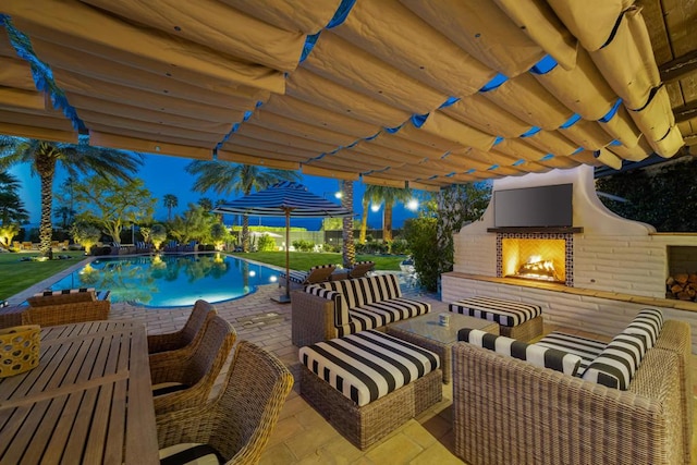 view of pool featuring an outdoor living space with a fireplace and a patio area