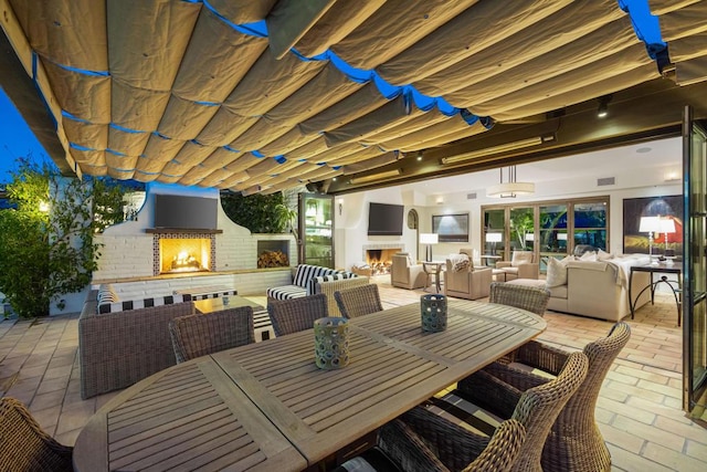 view of patio with an outdoor living space with a fireplace