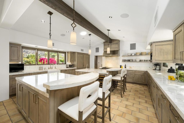 kitchen featuring a large island, lofted ceiling with beams, and a breakfast bar