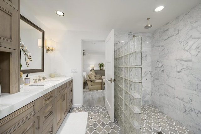 bathroom featuring ceiling fan, vanity, and tiled shower