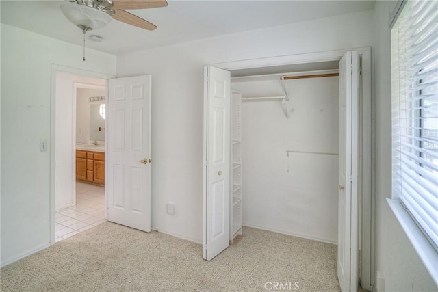 unfurnished bedroom featuring light colored carpet, a closet, and ceiling fan