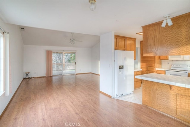 kitchen with tile countertops, white appliances, ceiling fan, decorative backsplash, and light hardwood / wood-style floors