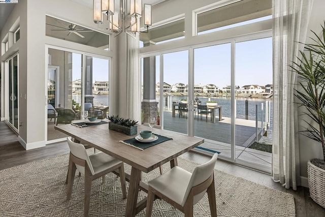 interior space featuring ceiling fan with notable chandelier, a healthy amount of sunlight, and a water view