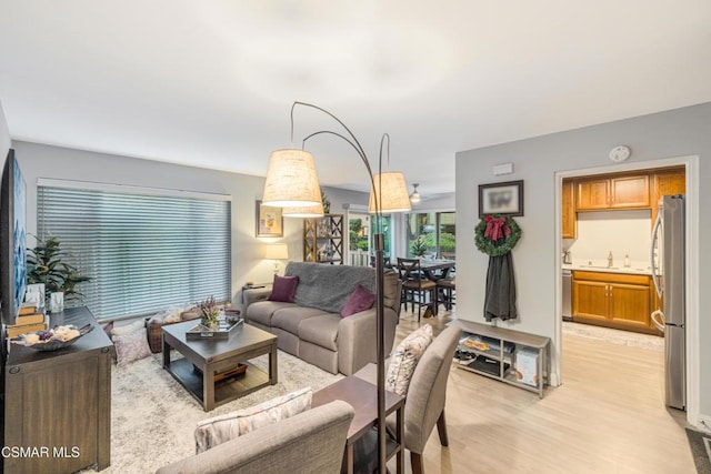 living room with light hardwood / wood-style floors and sink