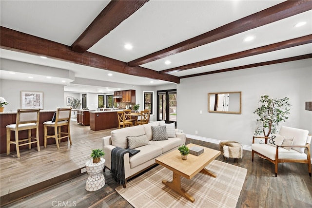 living room featuring beamed ceiling and light hardwood / wood-style flooring