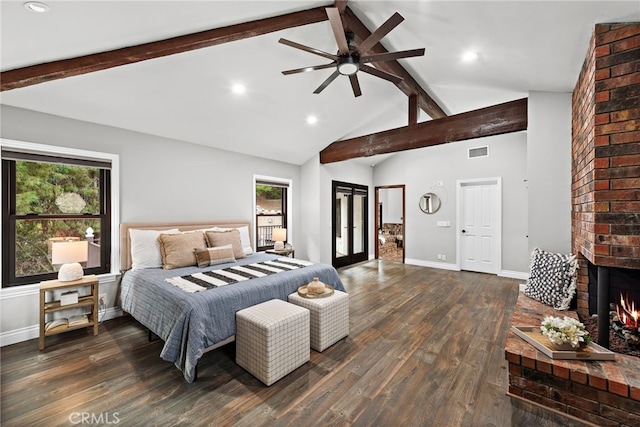 bedroom featuring a brick fireplace, ceiling fan, dark wood-type flooring, and multiple windows