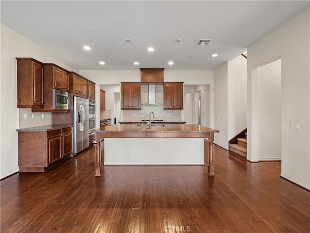26420 Township St, Saugus, CA 91350 - kitchen with wall chimney range hood, an island with sink, stainless steel appliances, decorative backsplash, and a breakfast bar area