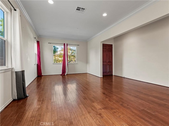 empty room featuring ornamental molding and hardwood / wood-style floors