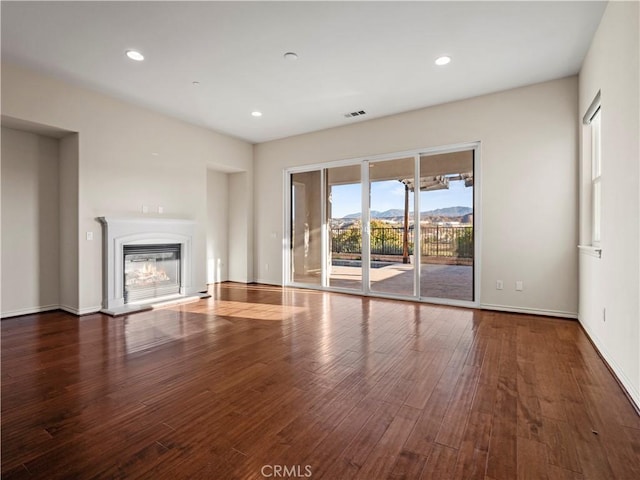 unfurnished living room with a mountain view and hardwood / wood-style floors