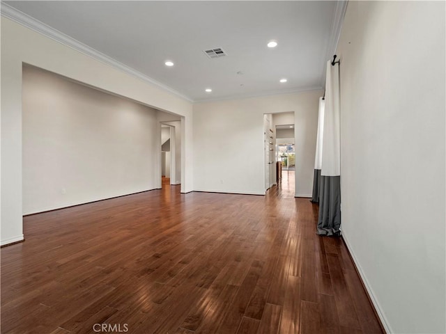 spare room featuring dark hardwood / wood-style flooring and crown molding