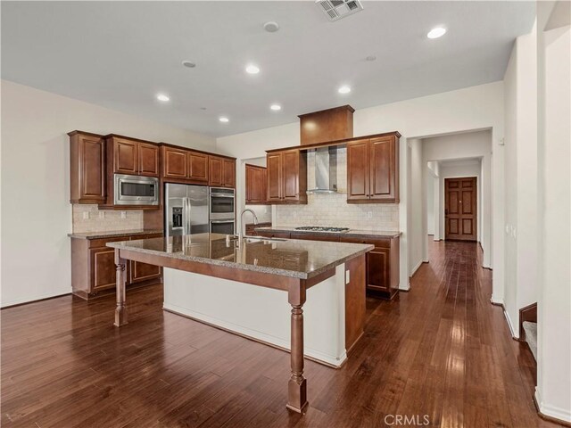 26420 Township St, Saugus, CA 91350 - kitchen featuring a kitchen breakfast bar, wall chimney range hood, visible vents, stainless steel appliances, and decorative backsplash