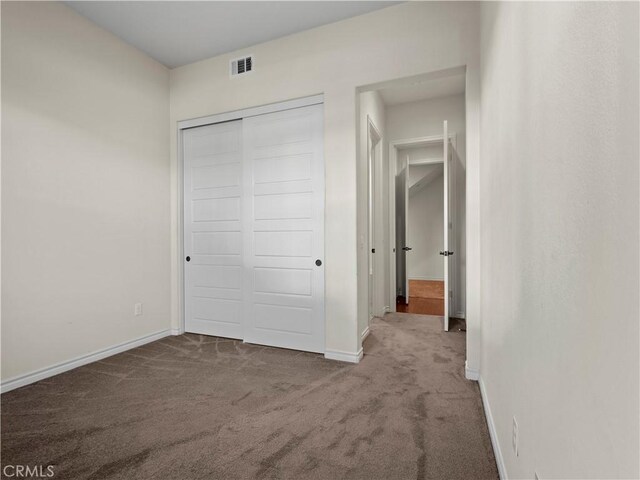 unfurnished bedroom with carpet flooring and a closet