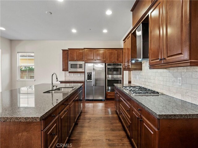 26420 Township St, Saugus, CA 91350 - kitchen featuring tasteful backsplash, wall chimney range hood, dark wood-type flooring, appliances with stainless steel finishes, and a sink