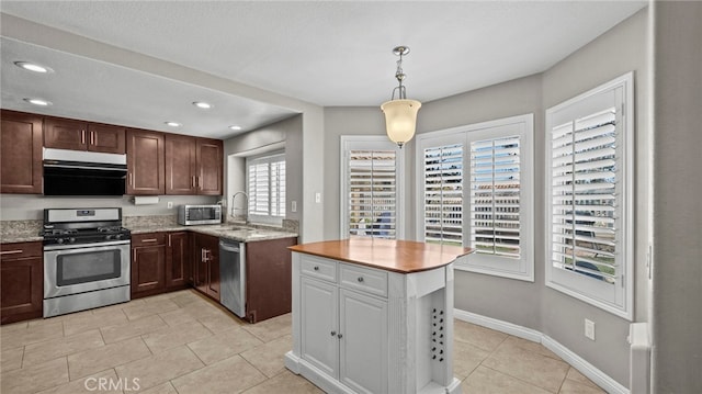 kitchen featuring sink, hanging light fixtures, a textured ceiling, appliances with stainless steel finishes, and light tile patterned flooring