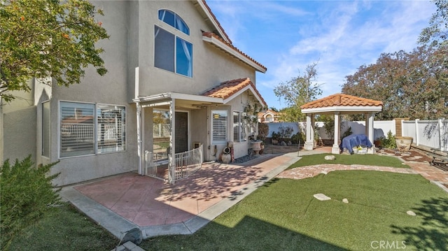 back of property with a yard and a patio