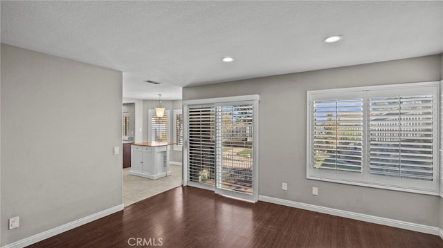 empty room with light hardwood / wood-style flooring and a textured ceiling