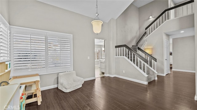 foyer entrance with a healthy amount of sunlight, dark wood-type flooring, and a high ceiling