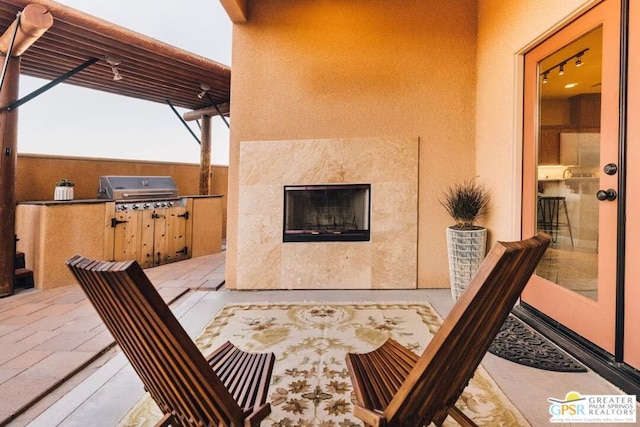 view of patio with a grill, area for grilling, and a tiled fireplace