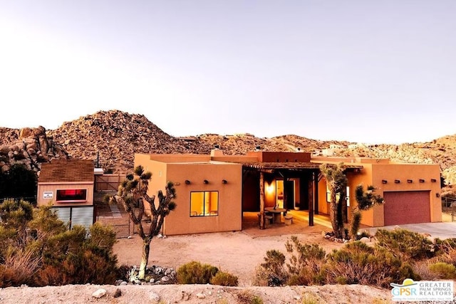 adobe home with a mountain view and a garage