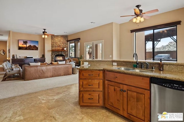 kitchen with dishwasher, a fireplace, plenty of natural light, and sink