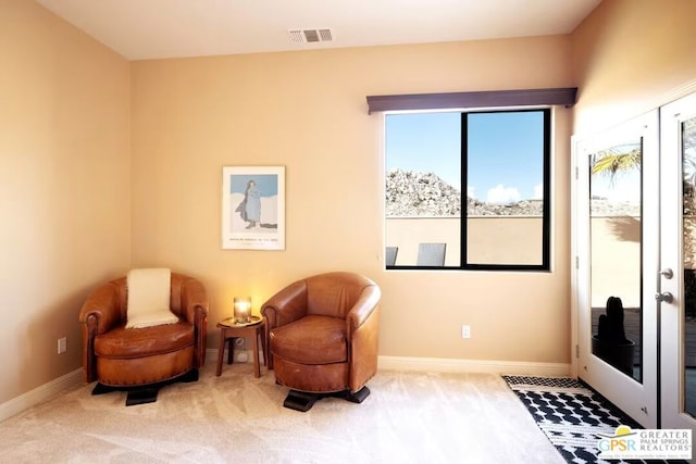 sitting room featuring carpet flooring and french doors