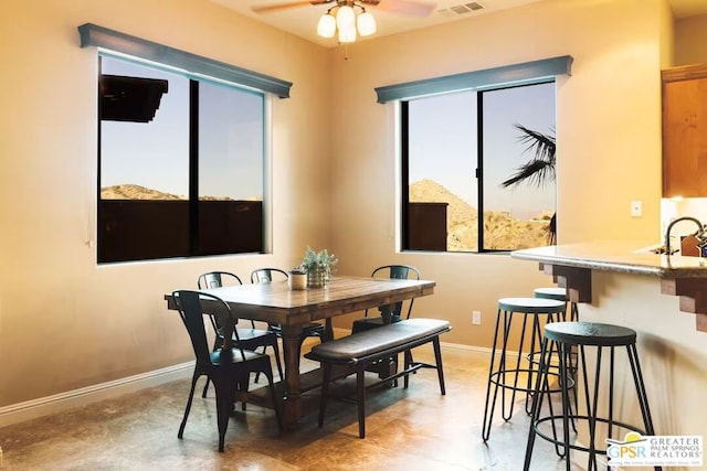 dining room featuring ceiling fan and sink