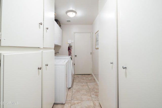 clothes washing area with washing machine and clothes dryer and cabinets