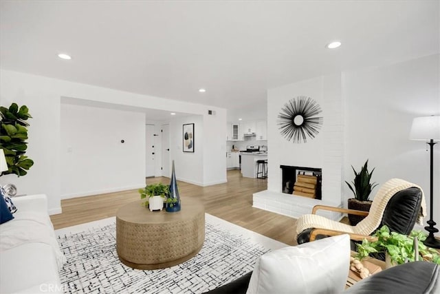 living room with a fireplace and light hardwood / wood-style flooring