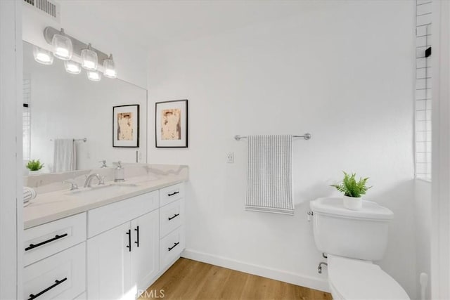 bathroom with vanity, wood-type flooring, and toilet