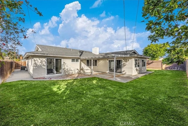 back of house featuring cooling unit, a yard, and a patio