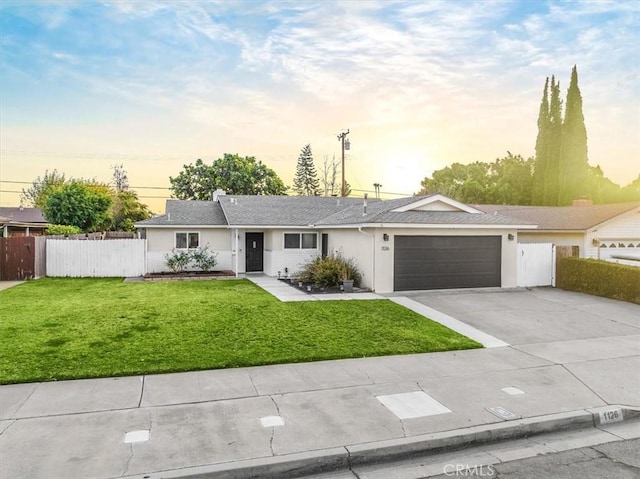 ranch-style home featuring a lawn and a garage