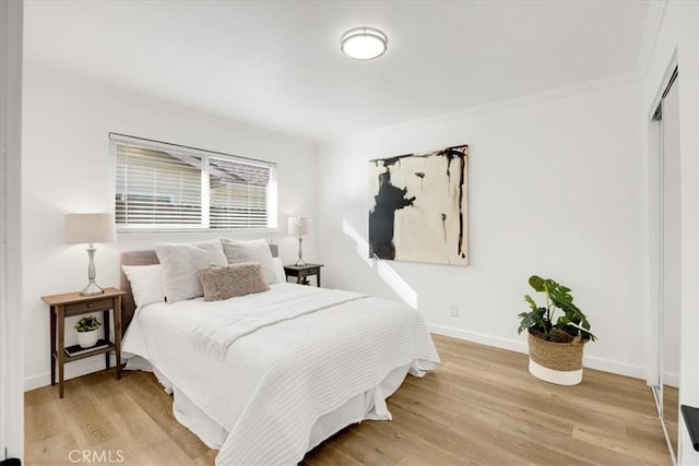 bedroom with light hardwood / wood-style floors and ornamental molding