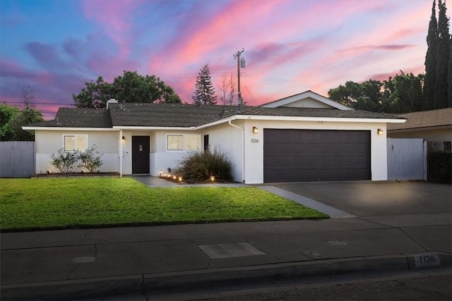 ranch-style house featuring a yard and a garage