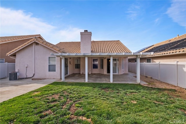 rear view of property featuring a yard, a patio area, and central air condition unit