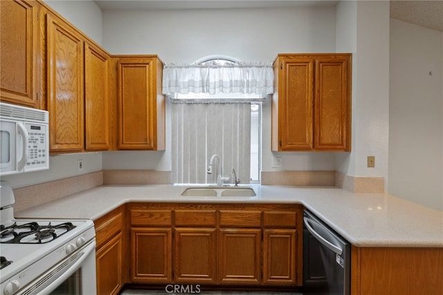 kitchen with vaulted ceiling, kitchen peninsula, sink, and white appliances