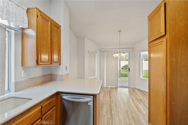 kitchen with dishwasher, kitchen peninsula, a chandelier, decorative light fixtures, and a textured ceiling