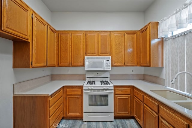 kitchen featuring sink, white appliances, and light hardwood / wood-style flooring