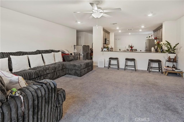 carpeted living room with ceiling fan