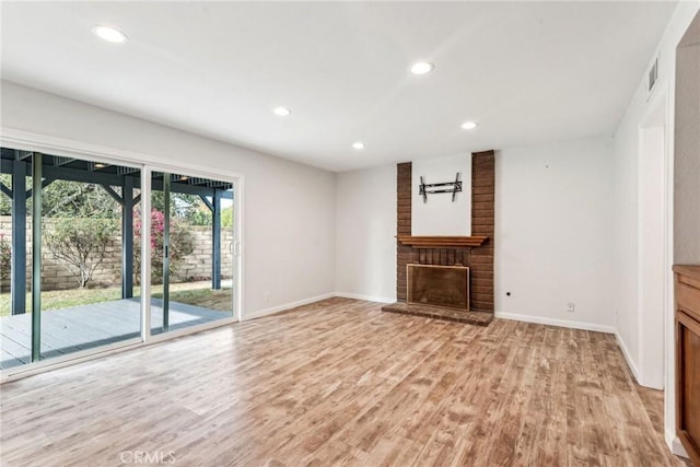 unfurnished living room with a fireplace and light hardwood / wood-style floors