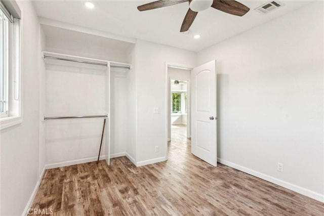 unfurnished bedroom featuring wood-type flooring, ceiling fan, and a closet