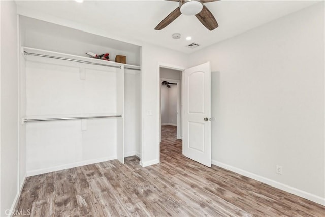 unfurnished bedroom featuring light hardwood / wood-style flooring, ceiling fan, and a closet