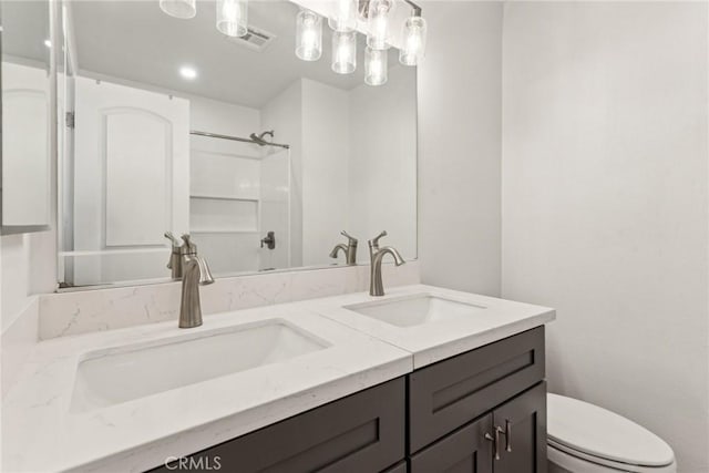 bathroom featuring vanity, toilet, and walk in shower