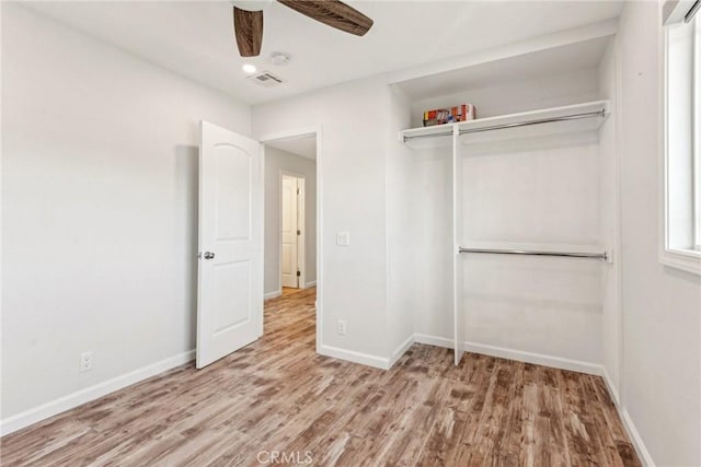 unfurnished bedroom featuring ceiling fan, light hardwood / wood-style floors, and a closet