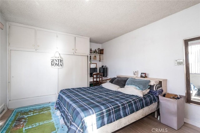 bedroom featuring wood-type flooring and a textured ceiling