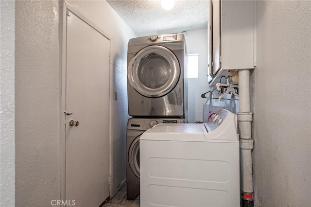 laundry area with stacked washing maching and dryer and a textured ceiling