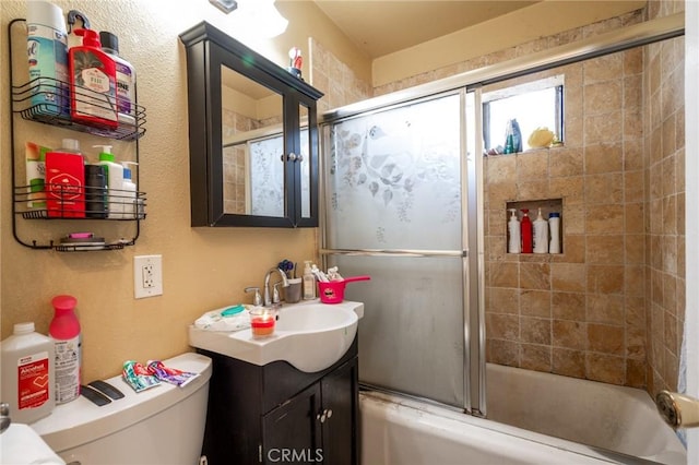 full bathroom with shower / bath combination with glass door, vanity, and toilet