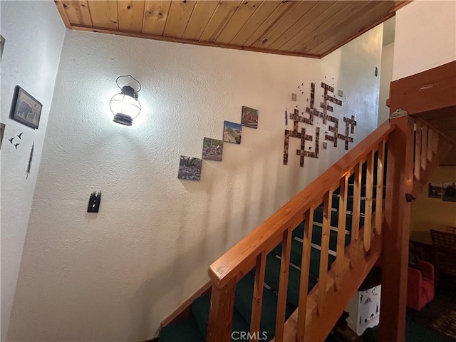 stairway with crown molding and wooden ceiling