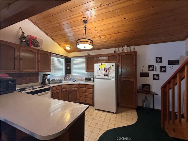 kitchen featuring kitchen peninsula, white appliances, vaulted ceiling, and hanging light fixtures