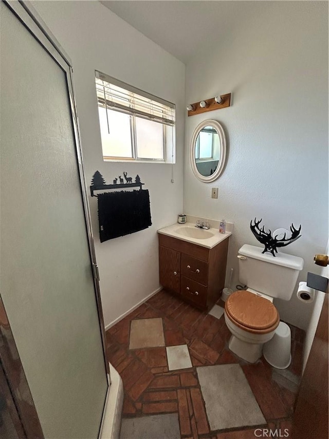 bathroom with vanity, toilet, and a shower with shower door