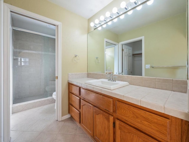 bathroom featuring vanity, toilet, tile patterned floors, and a shower with door